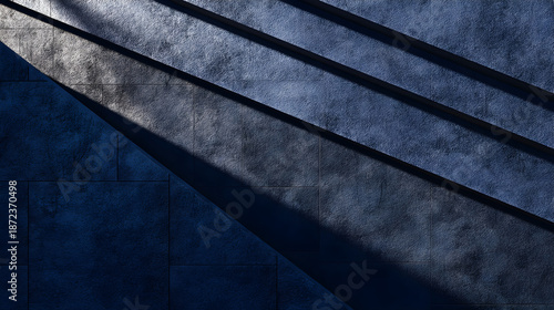 Modern concrete staircase with dramatic diagonal shadows in dark blue gray urban architecture interior