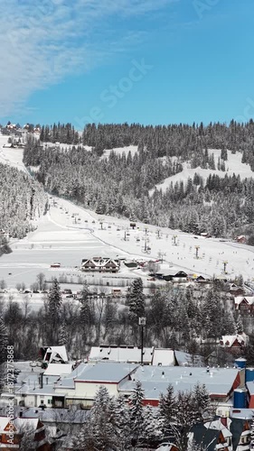 skiing in the mountains winter vertical portrait aerial drone footage ski lifts 