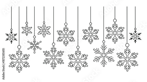 Collection of delicate line snowflakes hanging on strings against a white background winter cold