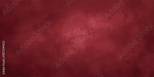 Abstract Dark red grunge background with rough concrete texture, scratches, and faded paint. Softly lit center and dark edges with a moody, creating a cold and desolate feeling, with empty space.