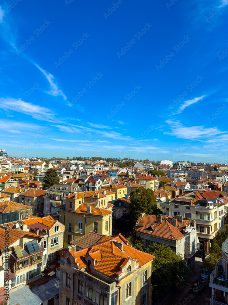 Fototapeta premium City view with houses and blue sky over rooftops in a residential area during daytime