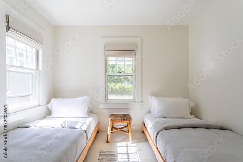 Fotografie Bright minimalist twin bedroom with two single beds and natural light, neutral m