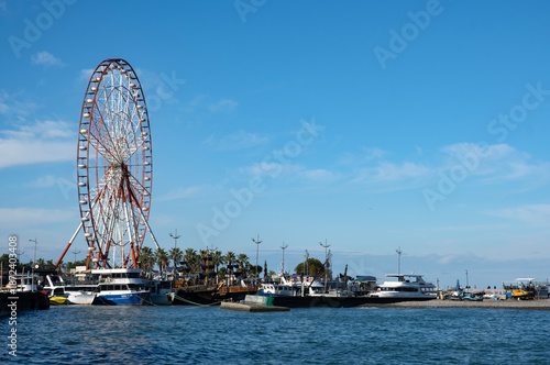 Ferris wheel and marina on a sunny coastal day