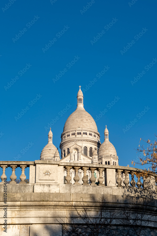 Fototapeta premium Sacré-cœur basilica featuring its white domes and architecture against a clear blue sky