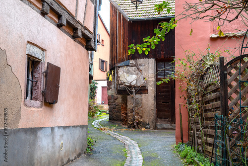 A curving alleyway and a deserted dirt road run through the village of Ribeauville in Alsace with its typical colourful houses