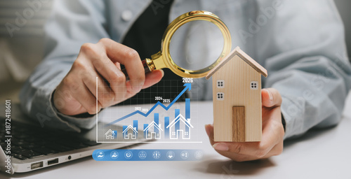 Property analysis concept, hands inspecting wooden house with magnifying glass and rising price chart, real estate evaluation, market research, investment decision, growth forecast
