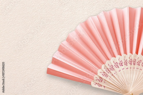 Vintage decorative hand fan in soft rose hue, showcasing intricate details and elegant design, perfect for adding a touch of charm to any setting or collection