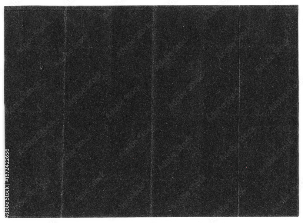 Fototapeta premium Black paper texture with visible fold lines on a neutral background, creating a minimalist and modern surface ideal for photo overlays and graphic design.