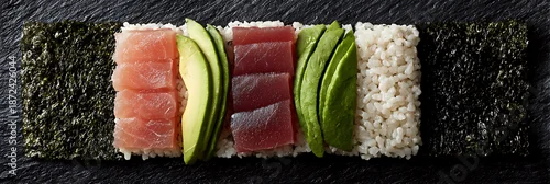 Obraz  z motywem Panoramic flat lay of deconstructed sushi roll ingredients on black slate: nori, rice, fresh tuna, salmon and avocado slices arranged in neat geometric rows for Japanese food banner