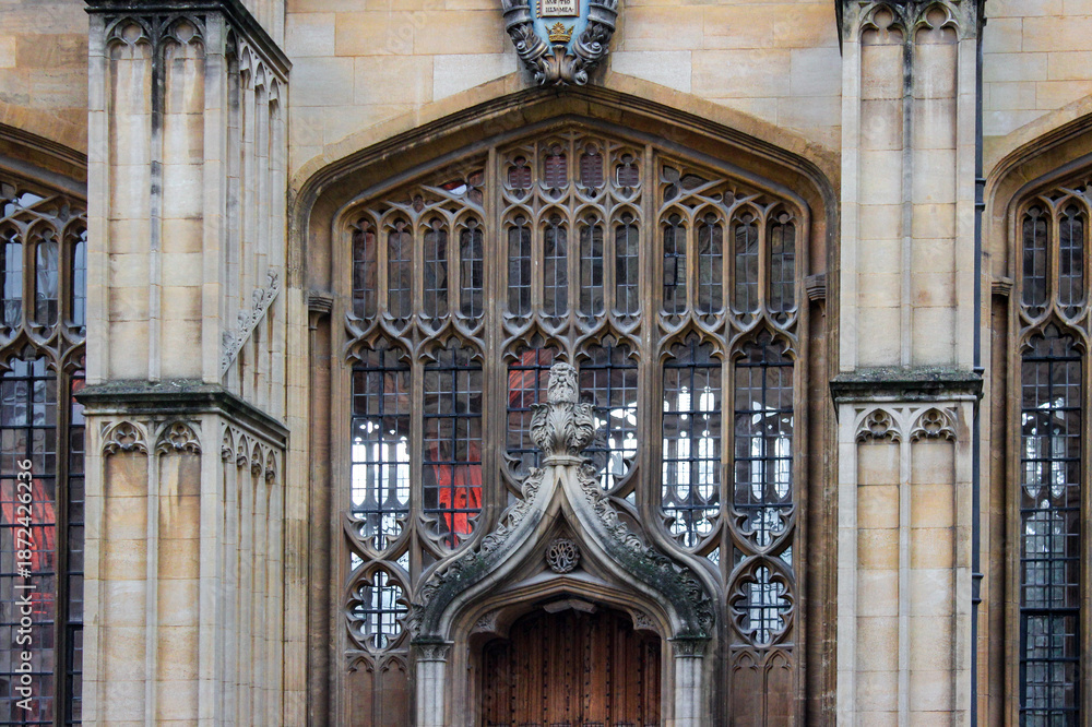 Fototapeta premium The ornate Gothic entrance to the Divinity School in Oxford. It features intricate stonework and tall stained-glass windows, a historic site known for its use as a Harry Potter filming location.