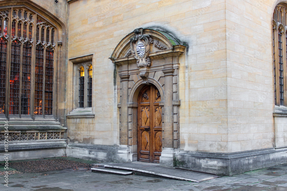 Fototapeta premium The ornate Gothic entrance to the Divinity School in Oxford. It features intricate stonework and tall stained-glass windows, a historic site known for its use as a Harry Potter filming location.