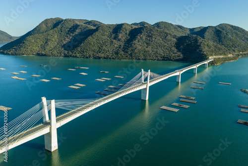 Winter aerial view of Bizen Hinase Bridge and oyster farming rafts in Seto Inland Sea, Japan.