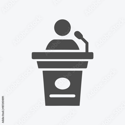 Simple figure stands behind podium and addresses unseen audience during formal speech