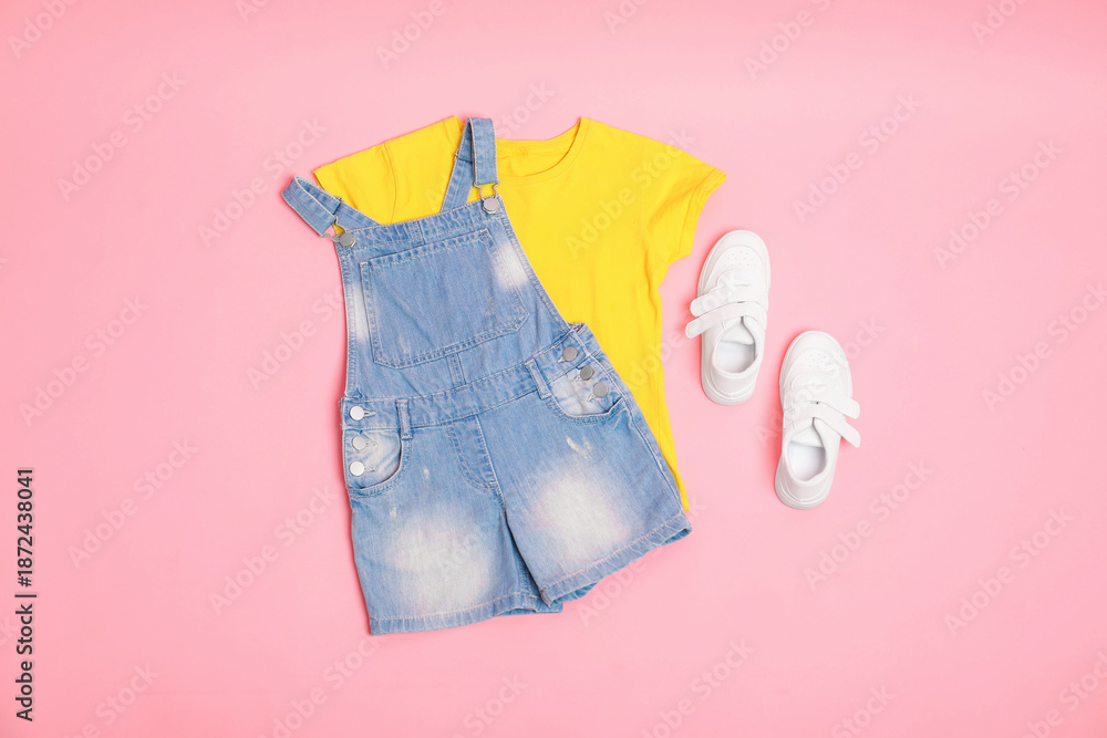 Fototapeta premium Stylish child clothes and shoes on pink background, flat lay