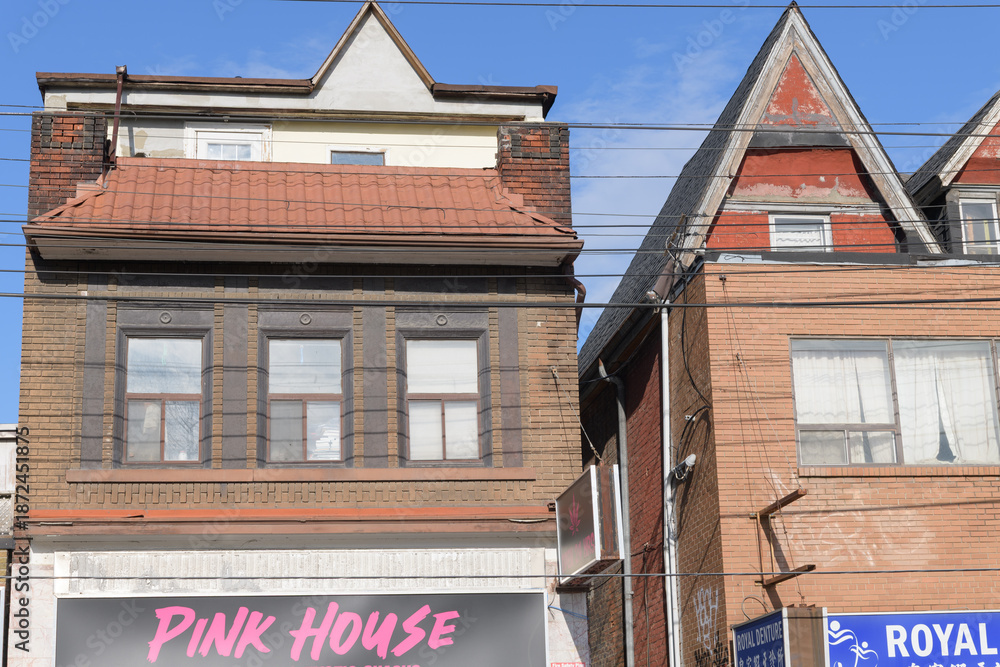 Fototapeta premium historic buildings including sign of Pink house Dispensary, a cannabis store, located at 574 Dundas St W, Toronto