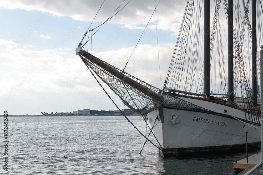 Naklejka premium Empire Sandy, a historic 200-foot three-masted schooner based in Toronto, originally built in 1943 as a British WWII deep-sea tugboat, later converted in the 1980s into a sail-rigged passenger ship