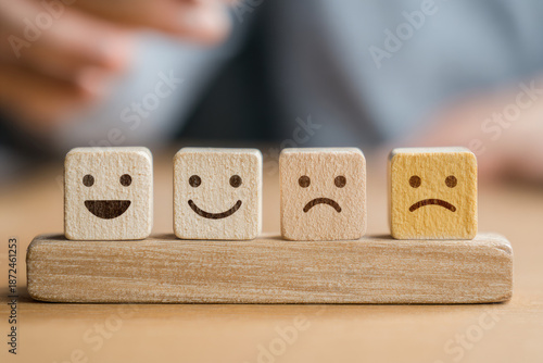 Customer service rating experience feedback emotion and satisfaction survey concept. Wooden labels with smile, normal and sad face icons, client chooses Positive Neutral or Negative pleasure score