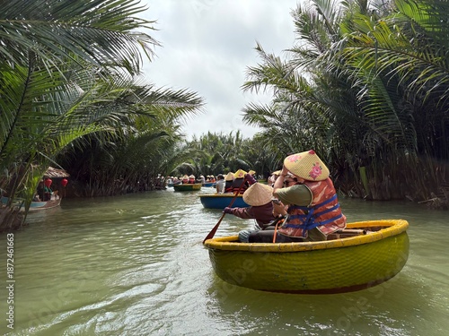 Foto Tourists on traditional basket boat ride through coconut forest in Hoi An, Vietn