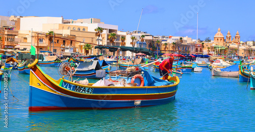 Photography The Luzzu is an iconic Maltese fishing boat, renowned for its vibrant colours and symbolic eyes painted on the prow