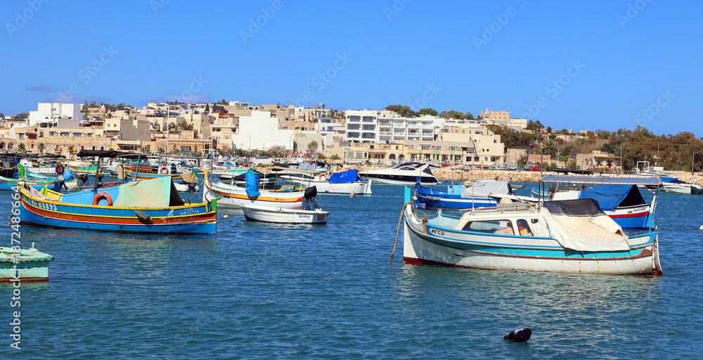 Obraz premium The Luzzu is an iconic Maltese fishing boat, renowned for its vibrant colours and symbolic eyes painted on the prow. Dating back to Phoenician times. MARSAXLOKK MALTA 