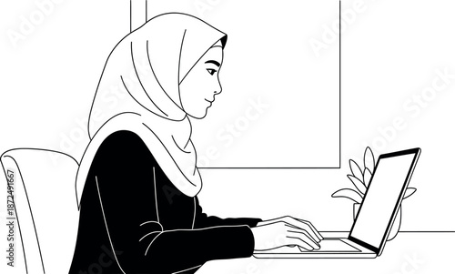 Young professional Muslim woman wearing a hijab focused intently on work using her laptop computer in a modern workspace