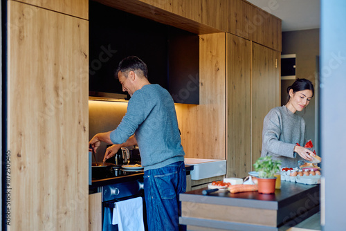 Foto Happy couple cooking in a contemporary kitchen