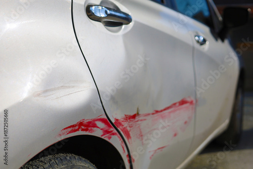 Car Side Panel with Red Paint Damage and Dent