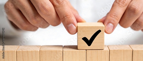 手と木製キューブが描くチェックマークのビジネスコンセプト