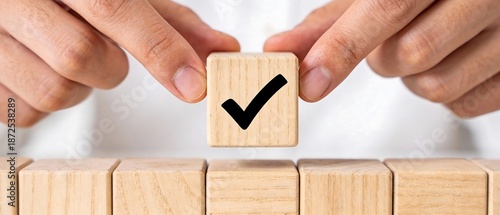 手と木製キューブが描くチェックマークのビジネスコンセプト