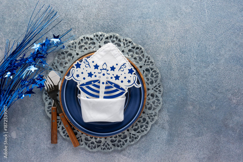 festive party place setting in shades of blue with sparkly starsand party decor on a blue mottled background
