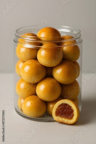 Traditional Indonesian Pineapple Tart Cookies Known as Nastar inside a Clear Plastic Jar, Popular Sweet Treat for Eid al-Fitr Celebration with Golden Crust and Sweet Pineapple Jam Filling