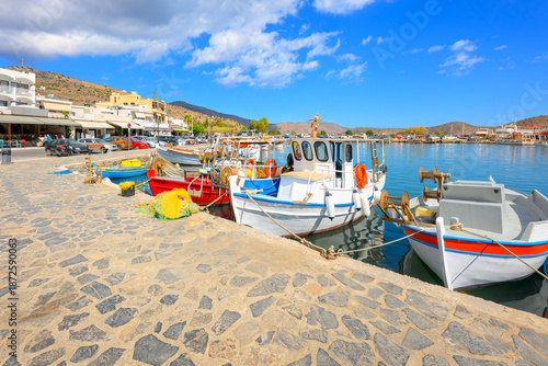 Colorful fishing boats line the marina at the picturesque seaside Greek town and resort of Elounda, in municipality of Agios Nikolaos, on the island of Crete.