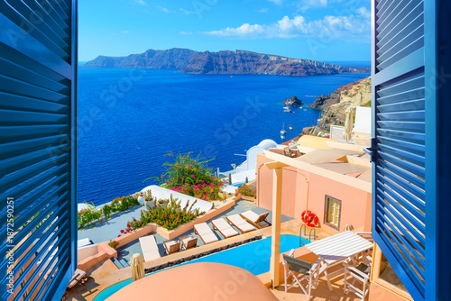 Bild auf Leinwand Sea view past blue window shutters of pastel and whitewashed terraces and houses at the idyllic Greek village of Oia, on the island of Santorini, Greece