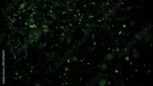 Dark abstract background with rising illuminated particles slowly drifting