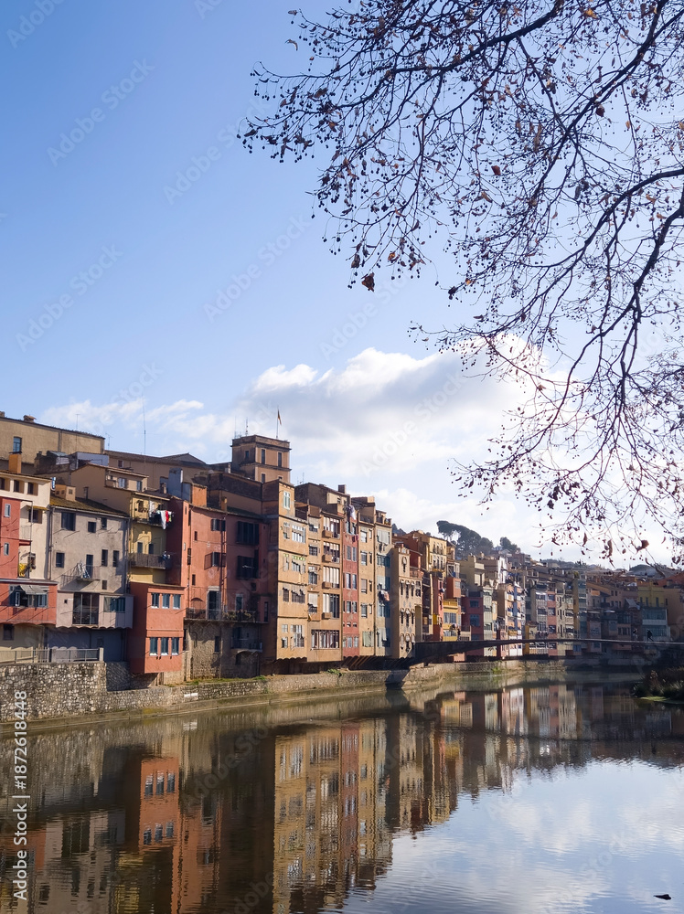 Fototapeta premium Colorful riverside houses reflected on calm water under blue sky, European old town cityscape with vibrant architecture, travel destination and urban landscape background
