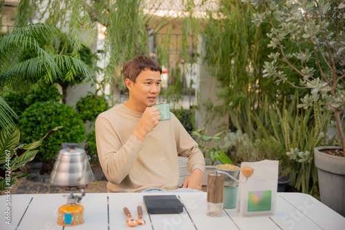Foto Asian man happily drip coffee beans in him home garden.
