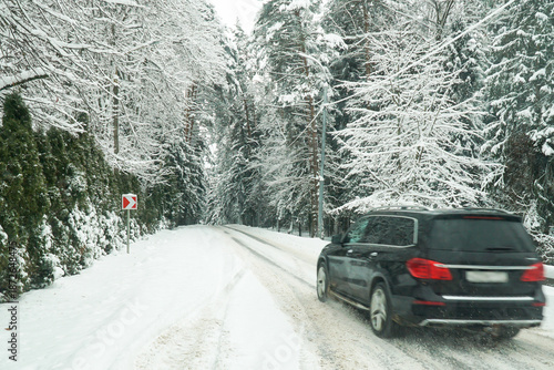 Car on a snowy winter road. Winter car travel on forest roads.