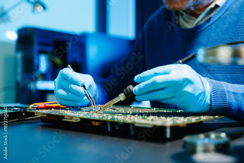 Professional electronics engineer testing a circuit board in a modern laboratory, concept of technology, repair, innovation, engineering