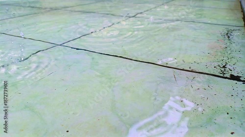 A cracked concrete floor surface is shown with water stains and intersecting structural lines. Construction texture concept