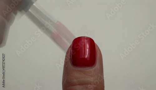 Red Nails Manicure. Woman painting red nails at home in close-up. Female hands carefully applying vibrant red nail polish with a brush for a perfect manicure., created with generative ai