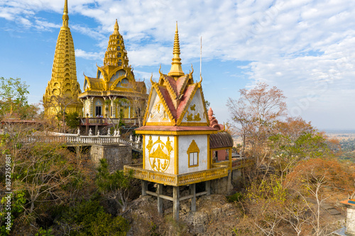 Vászonkép Ornate golden pagodas and a decorated temple pavilion stand atop the rocky cliffs of Phnom Sampov in Battambang province, Cambodia