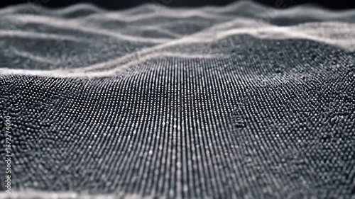 Closeup of textured fabric surface with tiny beads and intricate pattern in monochrome shades