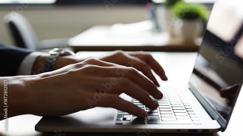 Professional hands typing fast on laptop during office work