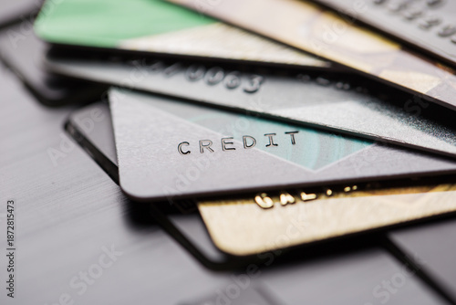 Colorful stack of credit cards and shopping gift cards on laptop keyboard close up . Selective focus. Macro with shallow dof.