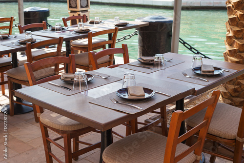 Outdoor scenery with tables and chairs seen in Madinat Jumeirah. Leisure, travel and tourism concept.