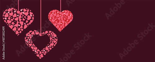 Three hanging pink hearts made of smaller hearts on dark purple background for valentines day or love concept