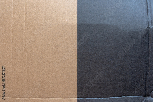 Texture comparison of corrugated cardboard half natural brown half painted dark gray