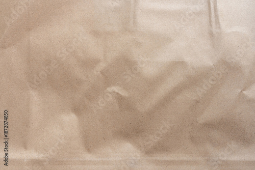 Crumpled light brown craft paper texture with visible wrinkles and subtle grain detail