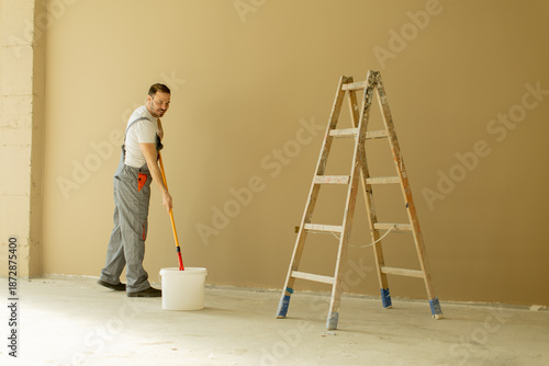 Man painting a wall with a ...