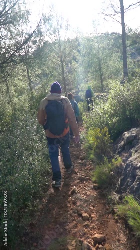 Slow motion, people hiking in the forest on a winter susnet.